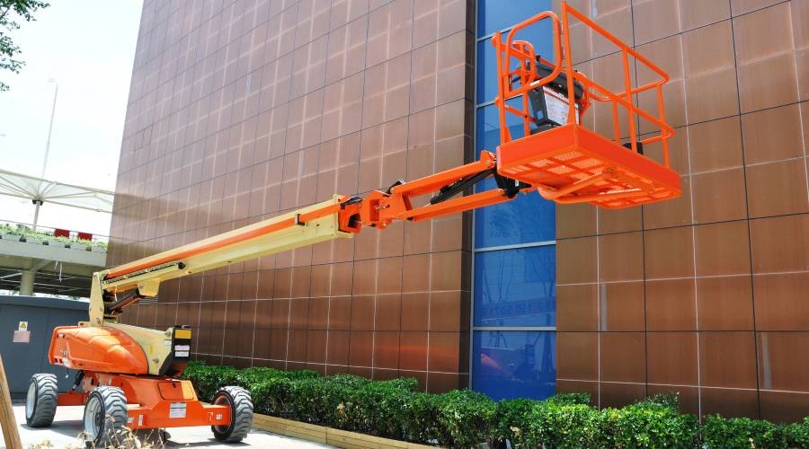 Oranje gekleurde hoogwerker Hoogwerker gebruiken voor werkzaamheden